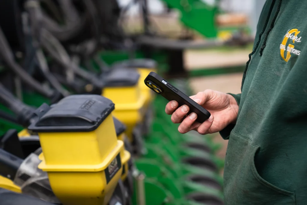 Man holding phone while standing in front of a planter