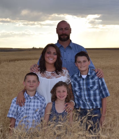 Clint and Ashley Jessen stand in front of a grain elevator.