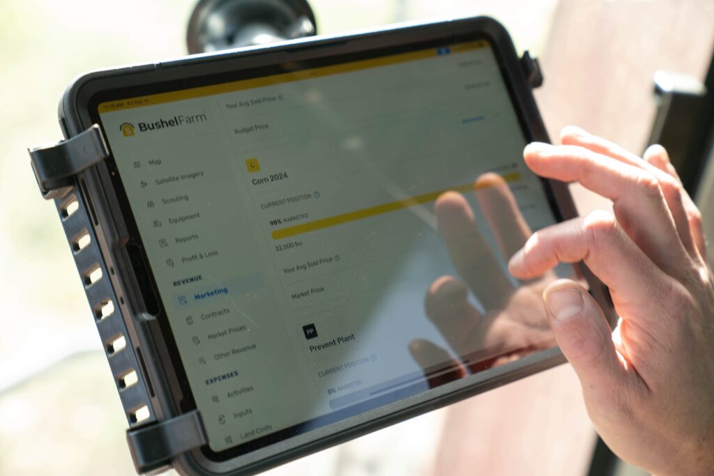 Tablet/iPad attached to window of a combine with a person's hand to tap on screen